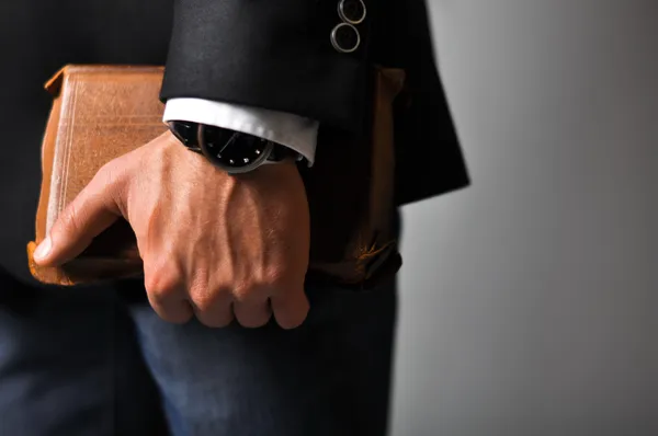 A businessman in a suit and jeans holding book — Stock Photo, Image