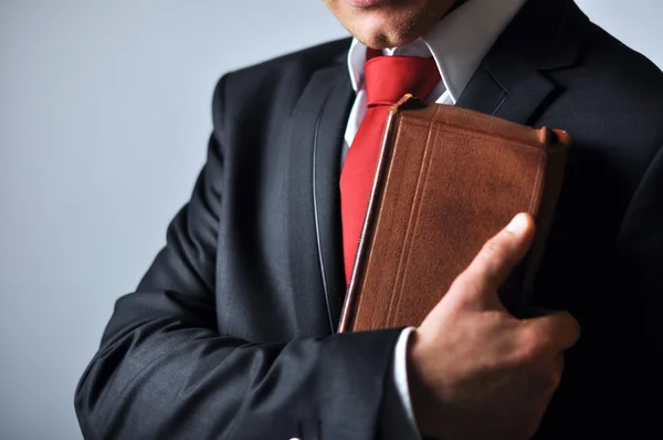 Businessman in a suit holding a book — Stock Photo, Image