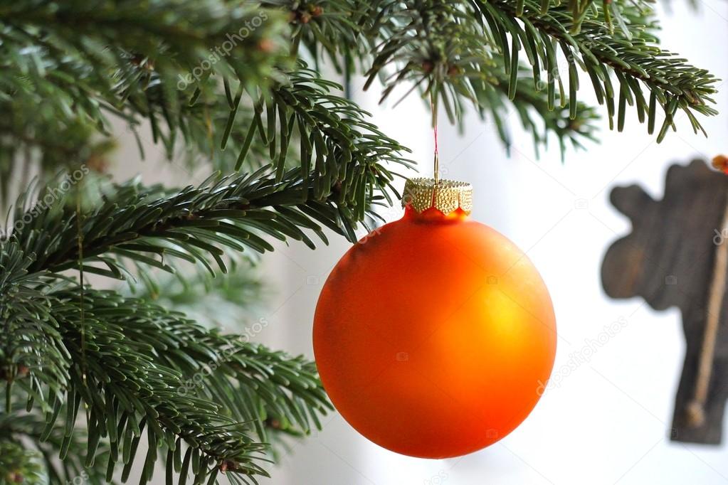 Orange Christmas bauble on branch