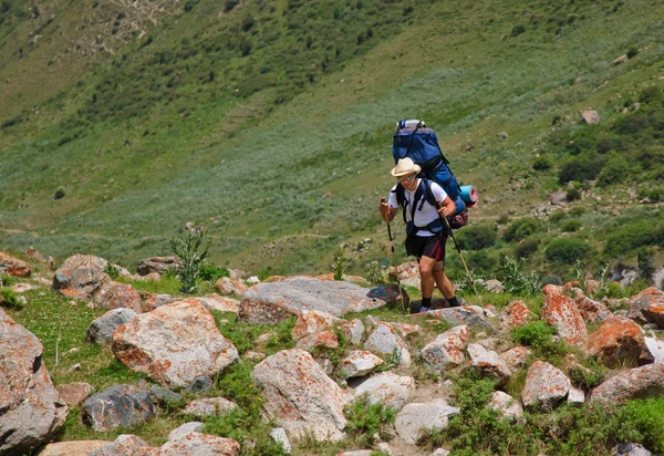 Un hombre con una mochila en el sendero de las montañas — Foto de Stock