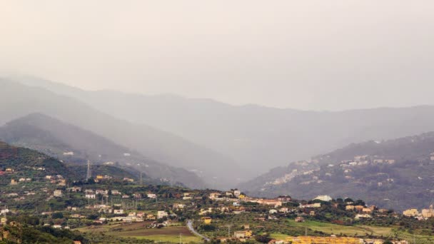 Village dans la vallée de montagne brouillard se cache . — Video