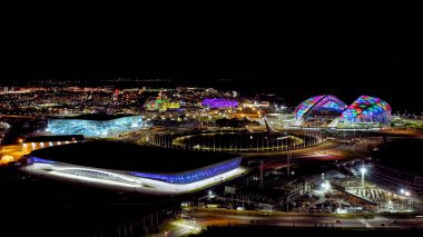Sochi, Rusya - 4 Eylül 2021 Olimpiyat Alevi ve Fisht Arena. Lunapark ve otel Bogatyr. Sochi 'deki Olimpik Park. Gece aydınlatması. Sirius Bölgesi, Hava Görünümü  