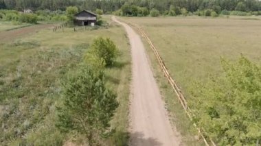 Rusya, Ural. Kırsal alan. Toprak yol, ahşap çit, ahşap kulübe. 4K