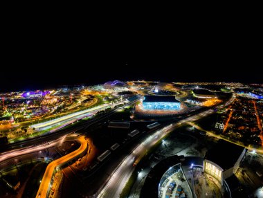 Sochi, Rusya - 5 Eylül 2021: Sochi Olimpiyat Parkı 'nın havacılık panoraması. Olimpik Alev Kasesi, Şarkı Söyleyen Çeşme. Bir gösteri var. Arena Fisht. Çok renkli bir aydınlatma. Gece