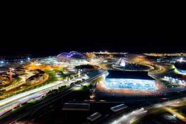 Sochi, Rusya - 5 Eylül 2021: Sochi Olimpiyat Parkı 'nın havacılık panoraması. Olimpik Alev Kasesi, Şarkı Söyleyen Çeşme. Bir gösteri var. Arena Fisht. Çok renkli bir aydınlatma. Gece