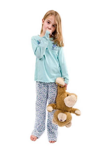 Girl in pajamas with teddy bear