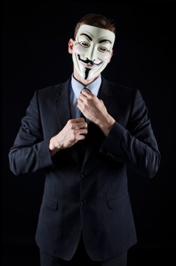 Man in suit wearing Vendetta mask