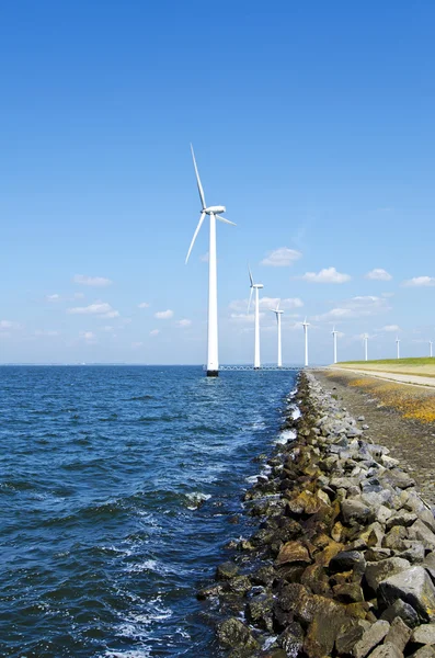 Energía alternativa en molinos de viento cerca del agua — Foto de Stock