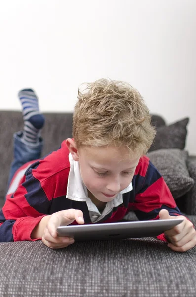 Junge auf Couch spielt mit ipad — Stockfoto