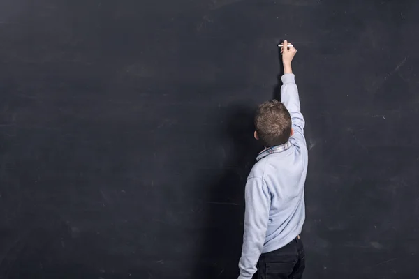 Kind schrijven op zwarte schoolbord — Stockfoto