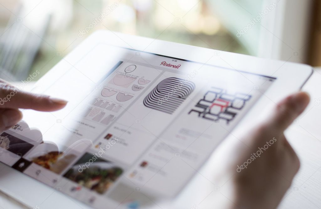 Homme utilisant une tablette numérique, doigt levé sur le smartphone