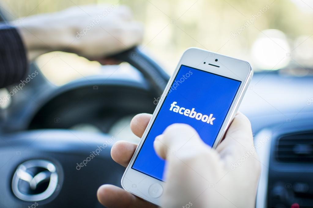 Man using facebook outdoors. Social media while driving risking ticket.