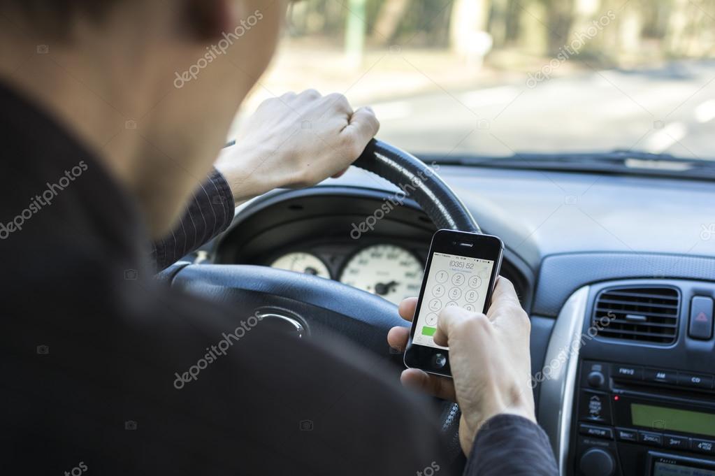 Calling behind the wheel, while driving a car. Dialing a number on Iphone.