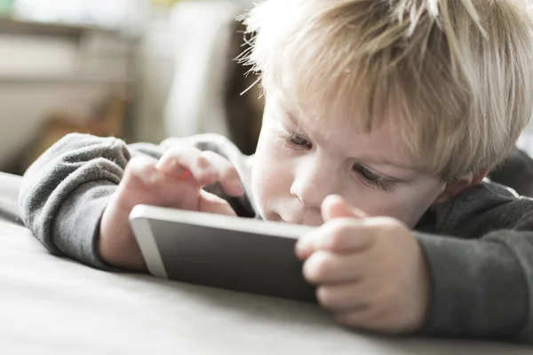 Boy playing games on smartphone — Stock Photo, Image