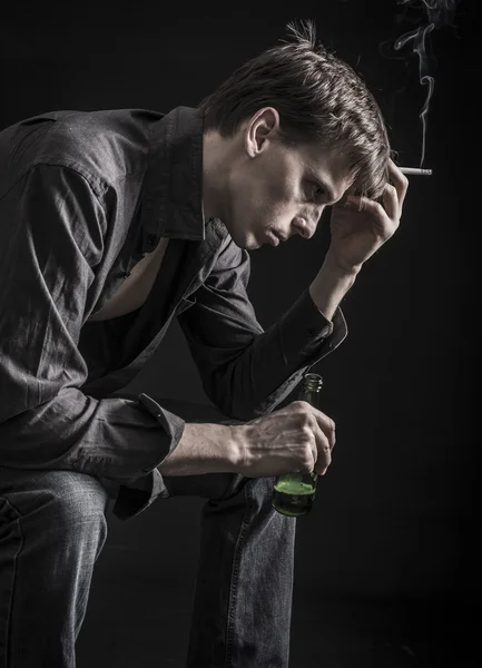 Depressed man drinking bear and smoking cigarette — Stock Photo, Image