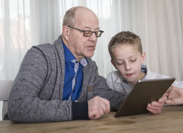 Ung pojke och farfar på TabletPC — Stockfoto