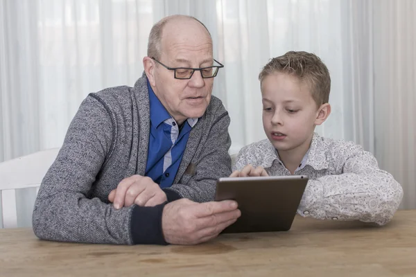 Ung pojke och farfar på TabletPC — Stockfoto