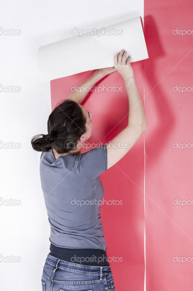 Woman hanging wallpaper.