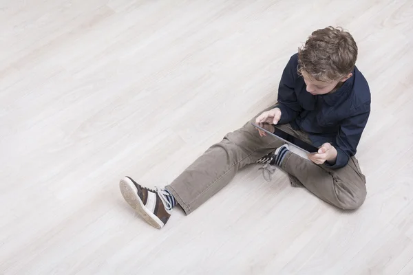 Menino no chão com tablet pc — Fotografia de Stock