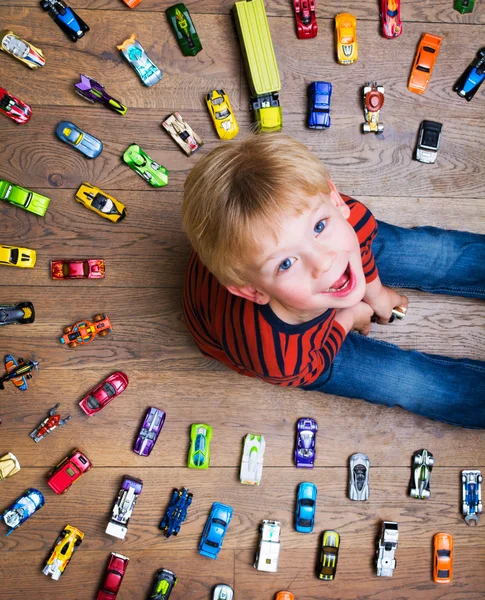 Pojken sitter med leksaksbilar — Stockfoto