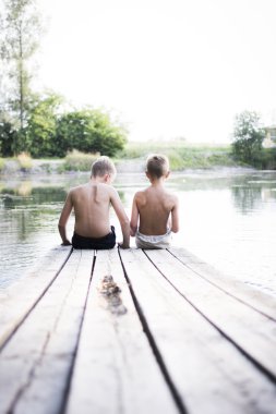 iki erkek bir iskelede oturup