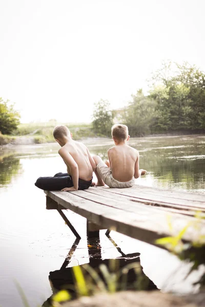 Dva kluci v doku jezero — Stock fotografie