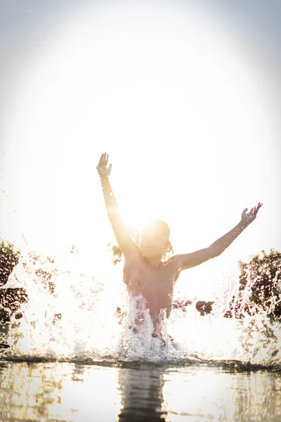 Niño divirtiéndose en un lago — Foto de Stock