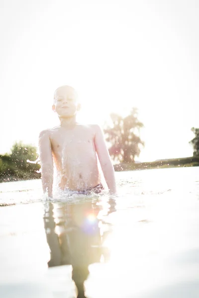 Niño divirtiéndose en un lago — Foto de Stock