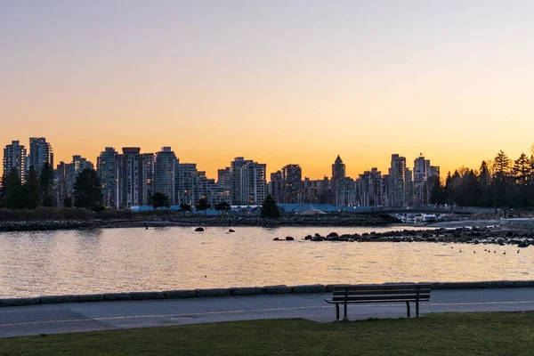 Alacakaranlıkta Stanley Park Seawall. Arka planda Vancouver şehir merkezi silueti var. British Columbia, Kanada. — Stok fotoğraf