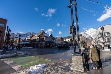 Banff, Alberta, Kanada - 23 Ocak 2022: Banff Bulvarı 'nda kış mevsimi. Yayalar covid-19 salgını sırasında karşıya geçiyorlar..