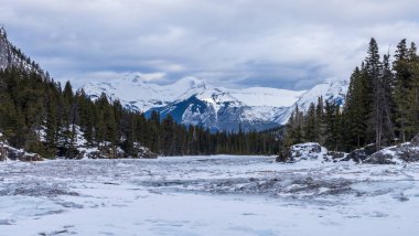 Kışın Donmuş Bow River, arka planda Kanada Kayalıkları. Banff Ulusal Parkı 'ndaki güzel manzara, Alberta, Kanada.