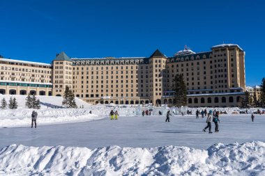 Louise Gölü, Alberta, Kanada - 27 Ocak 2022: Fairmont Chateau Gölü 'nde buz pateni pistinde kayan turistler.