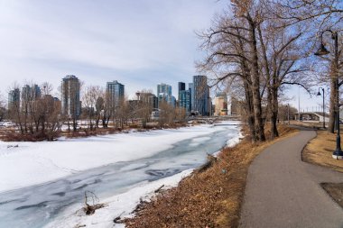 Calgary, AB, Kanada - 14 Mart 2022: Kışın Bow River Yolu. Donmuş Bow Nehri, St. Patrick Adası Parkı. Calgary şehir merkezi..