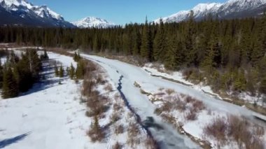 Drone kışın donmuş Bow River Vadisi ormanlarında uçar. Kanada 'nın dağlık dağları karla kaplı. Havadan panorama görüntüsü. Canmore, Alberta, Kanada.