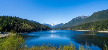 Baharda güneşli bir günde Capilano Gölü Cleveland Parkı. Panoramik manzara. Kuzey Vancouver, BC, Kanada.