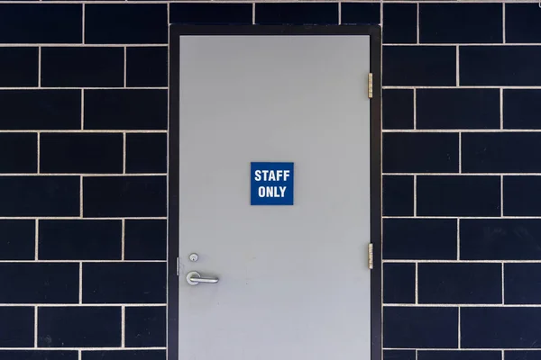 Staff only sign. Area for staff. Brick wall background.