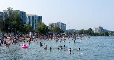 Barrie, Ontario, Kanada - 25 Temmuz 2021: İnsanlar yaz mevsiminde Centennial Park Plajı 'nda boş zaman aktiviteleri yapıyorlar. Kempenfelt Körfezi, Simcoe Gölü. Barrie Rıhtım Festivali. Su parklarına su sıçratma.