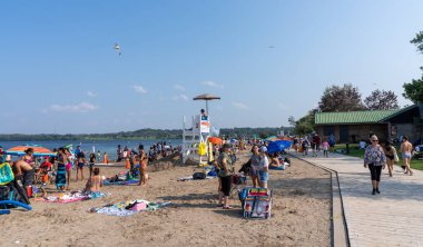 Barrie, Ontario, Kanada - 25 Temmuz 2021: İnsanlar yaz mevsiminde Centennial Park Plajı 'nda boş zaman aktiviteleri yapıyorlar. Kempenfelt Körfezi, Simcoe Gölü. Barrie Rıhtım Festivali. Su parklarına su sıçratma.