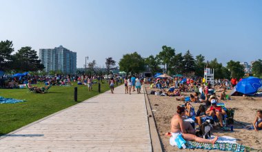 Barrie, Ontario, Kanada - 25 Temmuz 2021: İnsanlar yaz mevsiminde Centennial Park Plajı 'nda boş zaman aktiviteleri yapıyorlar. Kempenfelt Körfezi, Simcoe Gölü. Barrie Rıhtım Festivali. Su parklarına su sıçratma.