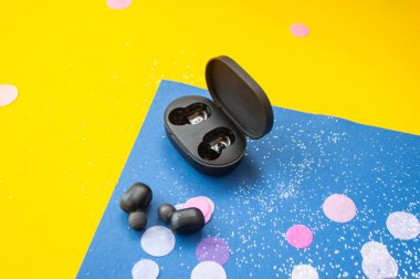 Kulaklıklar parlak sarı ve klasik mavi arka planda renkli konfeti ve kıvılcımlarla. Neşeli arkaplan.