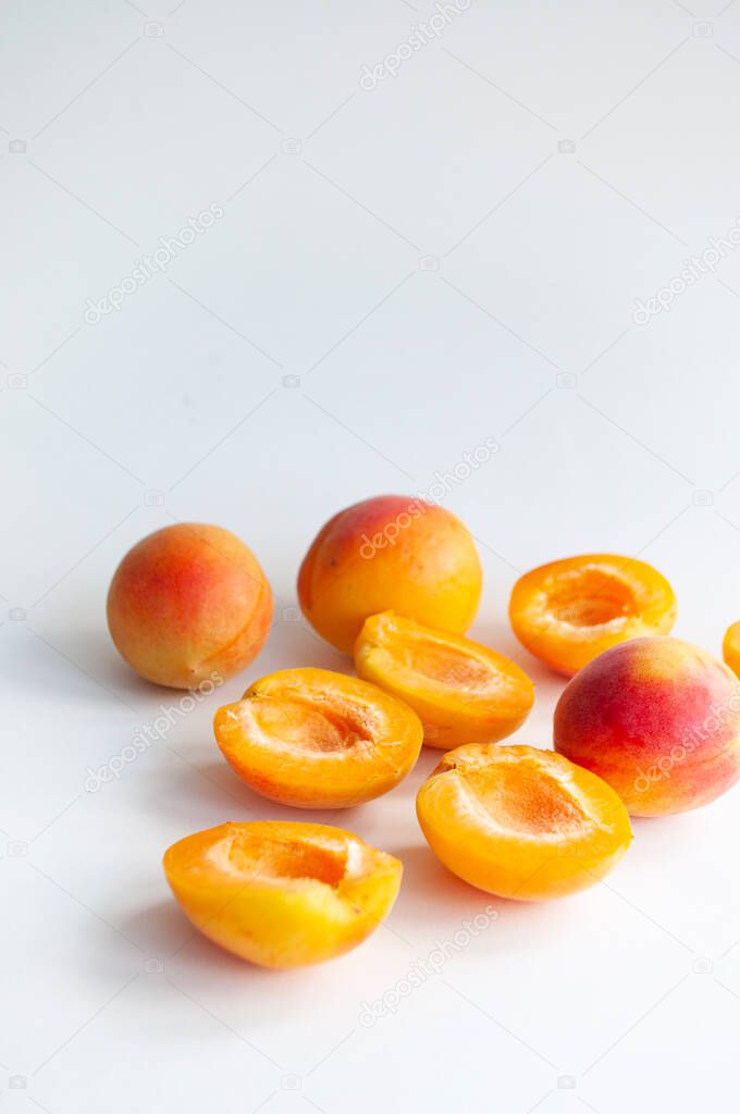 A ripe cut apricots with a seed on white background.