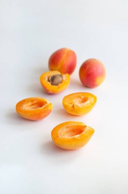 Tatlı olgun kesim ve beyaz arka planda kopyalanmış tohumlu kayısılar..