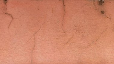 Eski turuncu duvarda çatlaklar ve soyulmuş boyalar..