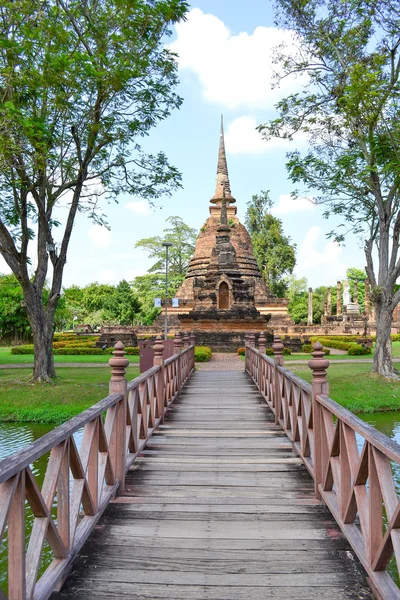 Rot gestrichene Brücke, die zu einem Inseltempel in Sukhothai führt — Stockfoto