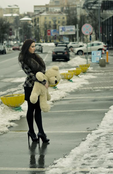 Fille avec un ours en peluche sur une rue — Photo