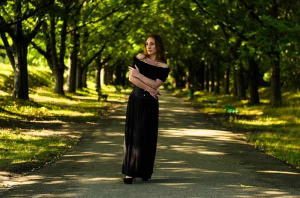 Fille dans une robe noire dans le parc — Photo