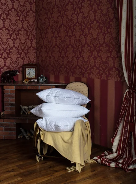 Rocking chair with pillows near the fireplace — Stock Photo, Image