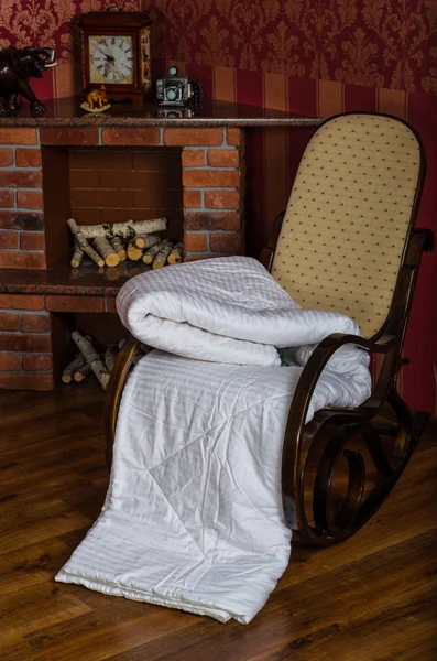 Fotel z narzuty przy kominku — Zdjęcie stockowe