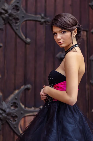 Tyttö poseeraa lähellä katolisen kirkon ovea — kuvapankkivalokuva