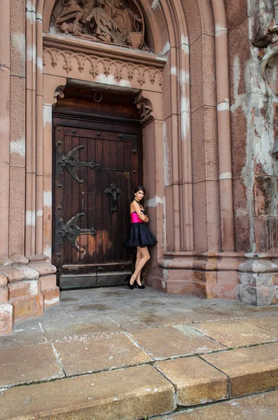 Girl posing near Catholic church — Stock Photo, Image